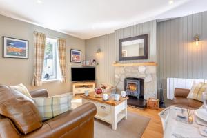a living room with a couch and a fireplace at 2 Bed in Newtonmore oc-e32418 in Newtonmore