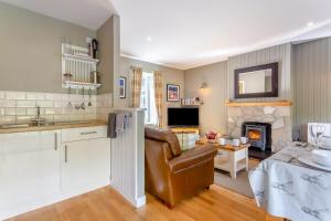 a kitchen and living room with a couch and a fireplace at 2 Bed in Newtonmore oc-e32418 in Newtonmore