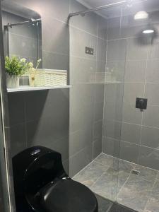 a bathroom with a black toilet and a glass shower at Apartamento en Itagüí in Itagüí