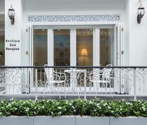 Elle comprend un balcon blanc avec des tables et des chaises. dans l'établissement Noursabah Boutique Bed Bangkok, à Bangkok