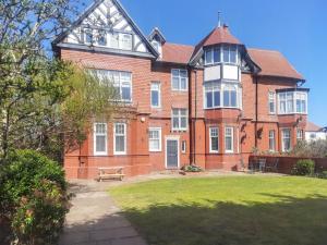 a large brick house with a bench in front of it at 3 Bed in Lytham St. Annes oc-m30622 in Saint Annes on the Sea