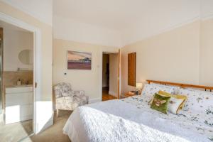 a white bedroom with a bed and a chair at 3 Bed in Lytham St. Annes oc-m30622 in Saint Annes on the Sea