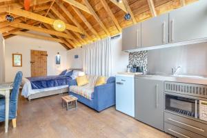 a kitchen and living room with a blue couch and a bed at 1 Bed in Swanage oc-l30493 in Langton Matravers