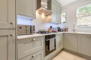 a kitchen with white cabinets and a stove top oven at 4 Bed in Swanage oc-a29454 in Swanage