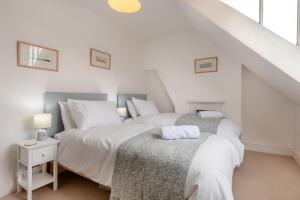 a white bedroom with two beds and a staircase at 4 Bed in Swanage oc-a29454 in Swanage