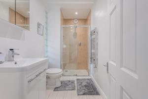 a white bathroom with a shower and a toilet at 4 Bed in Swanage oc-a29454 in Swanage +11 photos
