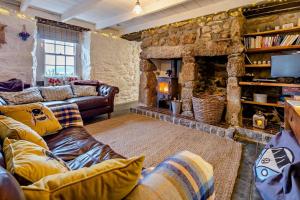 a living room with couches and a stone wall at 3 Bed in Sennen Cove oc-c29670 in Sennen