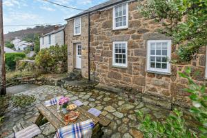 a stone house with a picnic table in front of it at 3 Bed in Sennen Cove oc-c29670 in Sennen