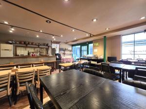 ein Restaurant mit Tischen und Stühlen und einer Bar in der Unterkunft Maron Hotel Nampo in Busan