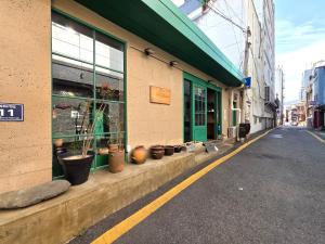 ein Gebäude mit Topfpflanzen am Straßenrand in der Unterkunft Maron Hotel Nampo in Busan