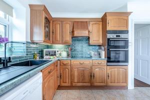 a kitchen with wooden cabinets and a sink at 1 Bed in Brynteg oc-g32079 in Llanwenog