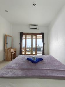 a bedroom with a bed with a view of the ocean at Dharma Yoga Homestay dan hostel in Amed