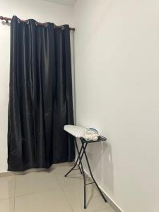 a black curtain in a room with a chair at RNA Homestay Bayan in Tawau +1 photo