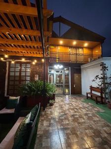 a house with a patio with benches and a deck at Hotel Boutique Casa Piedra in Tocopilla