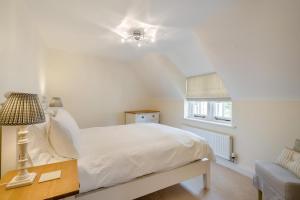 a bedroom with a white bed and a window at 3 Bed in West Lulworth oc-s32114 in West Lulworth
