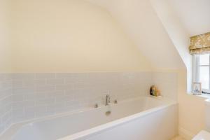 a white bath tub in a bathroom with a window at 3 Bed in West Lulworth oc-s32114 in West Lulworth +8 photos