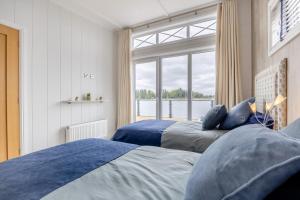 two beds in a bedroom with a large window at 2 Bed in Tallington oc-b32208 in Barholm
