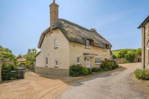 an old house with a thatched roof on a dirt road at 3 Bed in West Lulworth oc-s32114 in West Lulworth