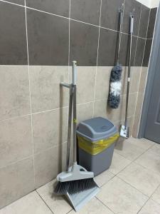 a bathroom with a broom and a trash can at RNA Homestay Bayan in Tawau