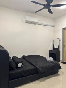 a bedroom with a black bed with a ceiling fan at RNA Homestay Bayan in Tawau