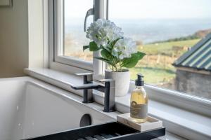 a bottle of wine sitting next to a window with a flower at 1 Bed in Llanover oc-y30114 in Llanover +26 photos