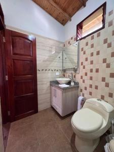 a bathroom with a toilet and a sink at Kumanday Lodge in Pereira
