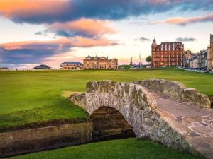 an old stone bridge over a field with buildings in the background at 1 Bed in St. Andrews oc-c30132 in St. Andrews