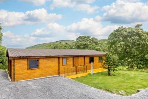 a small wooden cabin with a grassy yard at 3 Bed in Llanddulas oc-r27872 in Llanddulas