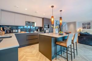 a kitchen with white cabinets and a island with bar stools at 2 Bed in Lancing oc-t29902 in Lancing