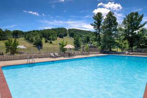a large blue swimming pool with tables and chairs at Liberty Mountain Lodging by Vail Resorts in Fairfield