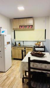 a kitchen with a table and a white refrigerator at Las andinas in Carmelo