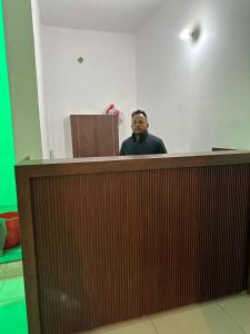 a man standing behind a counter in a room at Royal living hotal in Bathinda