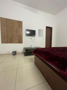 a bedroom with a bed and a tv on the wall at Royal living hotal in Bathinda +1 photo