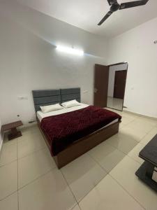 a bedroom with a bed in a white room at Royal living hotal in Bathinda