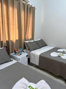 a bedroom with two beds with towels on the floor at Pousada Nova Estrela da Canastra in Delfinópolis