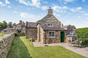 an old stone house with a table and chairs at 1 Bed in Warslow oc-h27591 in Warslow