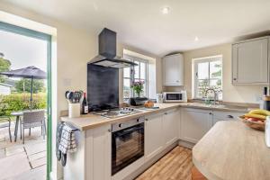 a kitchen with white cabinets and a stove top oven at 1 Bed in Warslow oc-h27591 in Warslow +10 photos