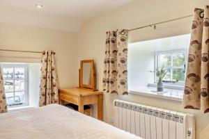 a bedroom with a bed and a mirror and a window at 1 Bed in Warslow oc-h27591 in Warslow