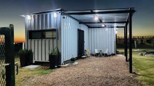 a metal building with a garage with a table at Las andinas in Carmelo