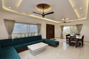 a living room with a green couch and a table at Navishka'S Villa in Panchgani