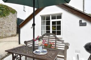 a table with a chair and an umbrella at 2 Bed in Westward Ho oc-n0987 in Westward Ho