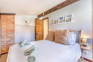 a bedroom with a white bed with a brick wall at 2 Bed in Sheringham oc-2310 in Sheringham