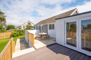a wooden deck with a table on a house at 3 Bed in Higher Crackington oc-avond in Crackington Haven