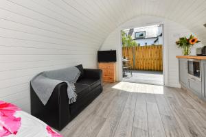 a living room with a couch and a television at 1 Bed in Abersoch oc-thepod in Abersoch