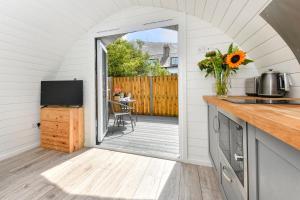 a kitchen with a door leading to a deck with a table at 1 Bed in Abersoch oc-thepod in Abersoch