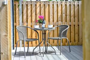 a patio table with two chairs and a vase with flowers at 1 Bed in Abersoch oc-thepod in Abersoch +3 photos