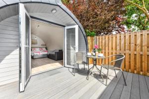 a patio with a table and chairs on a deck at 1 Bed in Abersoch oc-thepod in Abersoch