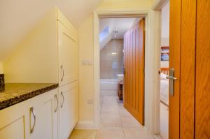 a kitchen with white cabinets and a hallway at 1 Bed in Woodstock oc-u30547 in Kidlington +17 photos