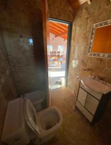 a bathroom with a toilet and a sink at Casona de Montaña in Los Hornillos