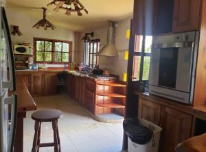 a kitchen with wooden cabinets and a large television at Casona de Montaña in Los Hornillos +25 photos